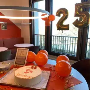 Foto aus dem Büro. Kuchen und Luftballons liegen auf dem Tisch