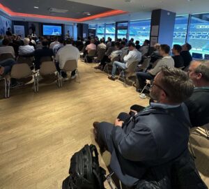 Teilnehmende der AI Reality Tour Hamburg im Vortrag – Blick auf Bühne und Innenraum des Volksparkstadions